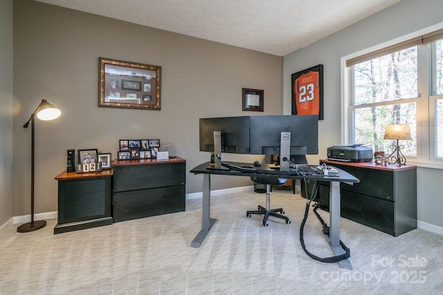 carpeted office with a healthy amount of sunlight and baseboards