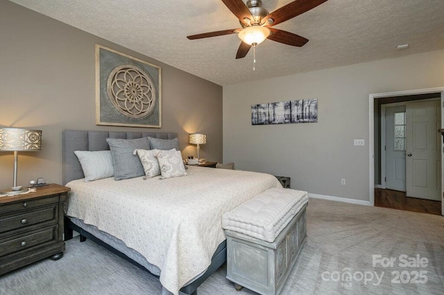 carpeted bedroom with a ceiling fan, baseboards, and a textured ceiling