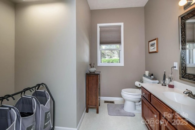 half bathroom with visible vents, baseboards, toilet, and vanity