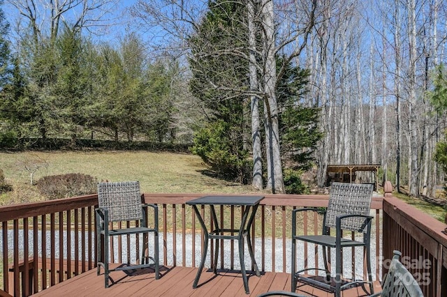 wooden deck featuring a lawn