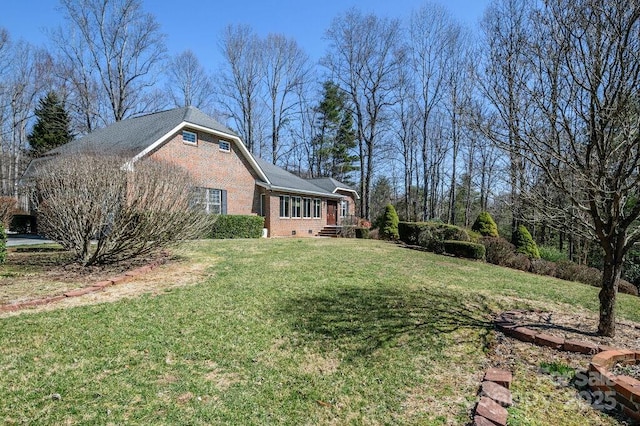 exterior space featuring a lawn and brick siding