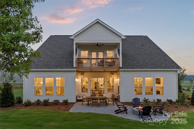 back of house with a patio, a balcony, a yard, and an outdoor fire pit