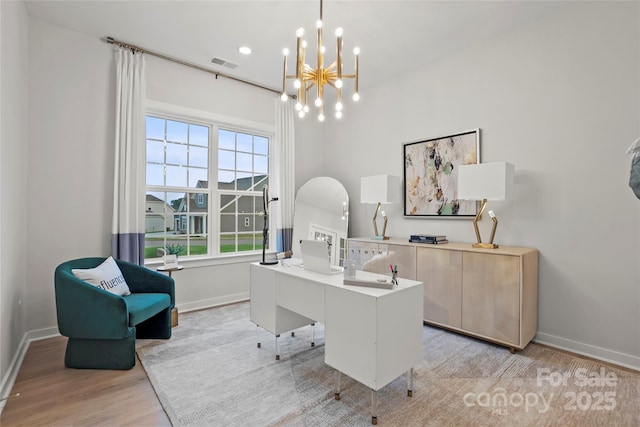 office space featuring light wood-type flooring, visible vents, and baseboards