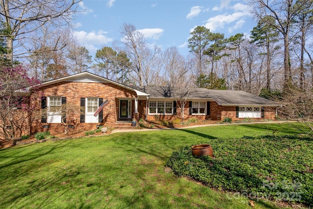 ranch-style house featuring a garage, brick siding, and a front lawn