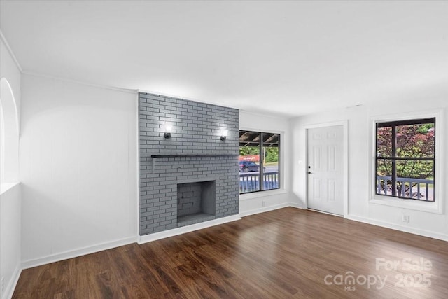 unfurnished living room with a fireplace, baseboards, and wood finished floors