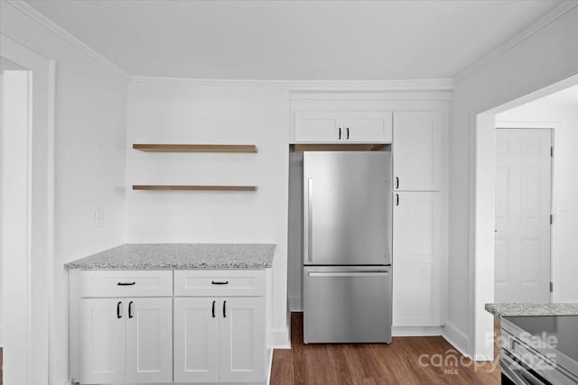 kitchen featuring dark wood-style floors, white cabinets, freestanding refrigerator, and light stone countertops