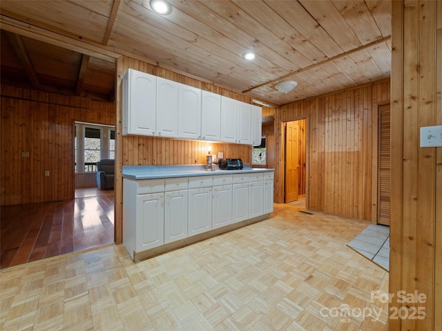 140 Hangin Dog Ln, Lake Toxaway, NC 28747 - kitchen featuring parquet floors, wooden ceiling, wood walls, and white cabinetry