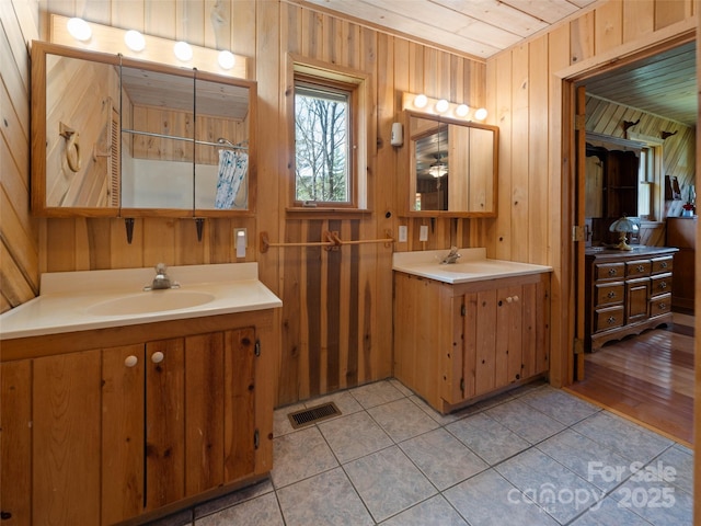 140 Hangin Dog Ln, Lake Toxaway, NC 28747 - bathroom with a sink, visible vents, tile patterned flooring, and wooden walls