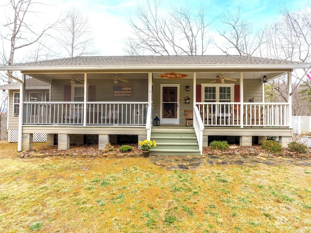 view of front facade featuring covered porch, a shingled roof, and a ceiling fan