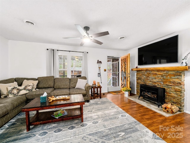 living room featuring ceiling fan, visible vents, and wood finished floors