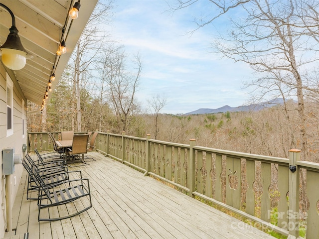 deck featuring outdoor dining area and a mountain view