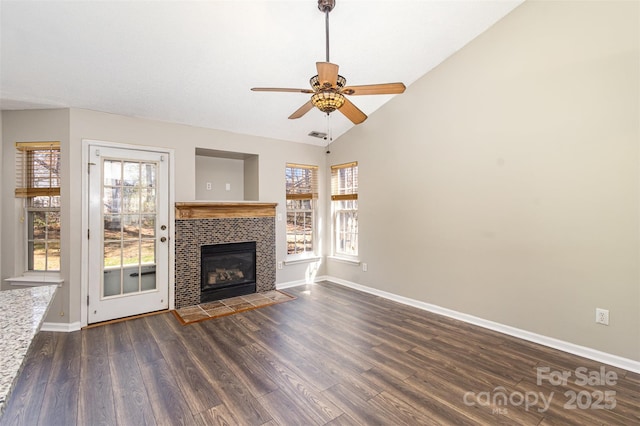 unfurnished living room with a fireplace, dark wood-type flooring, baseboards, and vaulted ceiling