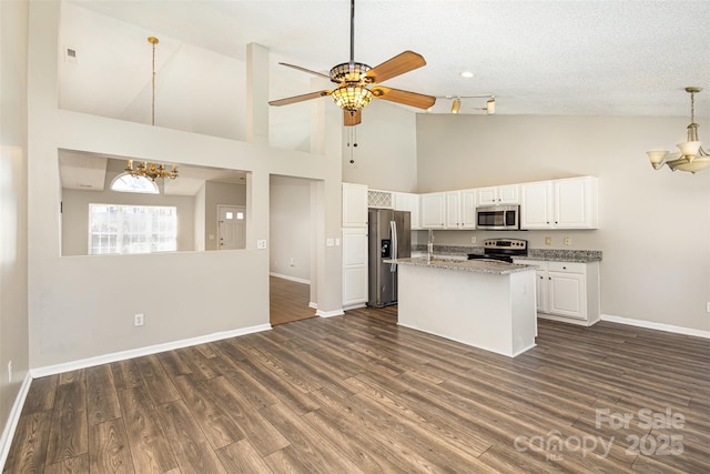 kitchen with pendant lighting, dark wood finished floors, white cabinetry, appliances with stainless steel finishes, and baseboards