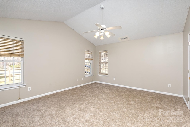 spare room featuring visible vents, lofted ceiling, a ceiling fan, carpet flooring, and baseboards