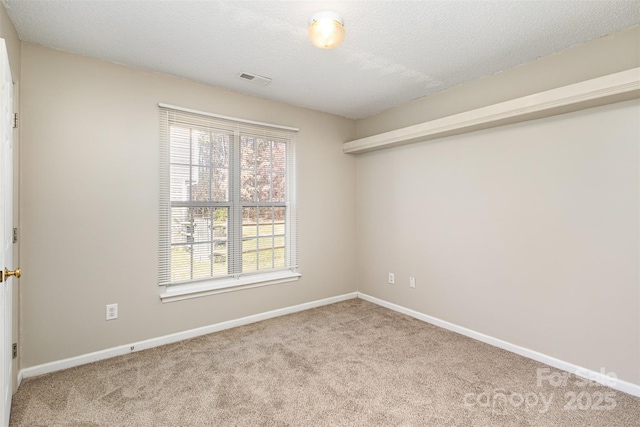 carpeted empty room featuring visible vents, baseboards, and a textured ceiling