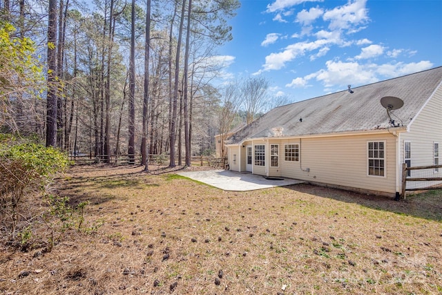 back of property with a patio area, a lawn, and fence