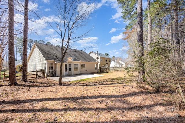 rear view of house with a patio area and fence