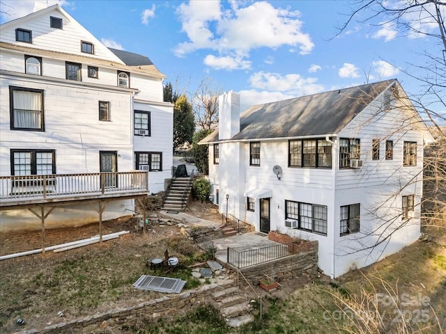 back of property featuring cooling unit, a chimney, and stairs