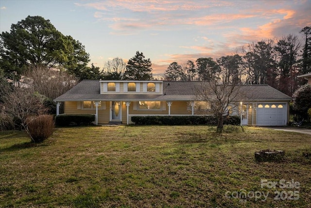 view of front of house featuring an attached garage, driveway, and a front lawn