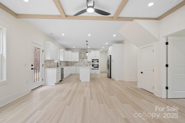 10405 Briarhurst Pl Unit 18, Mint Hill, NC 28227 - kitchen with appliances with stainless steel finishes, a sink, wall chimney range hood, a kitchen island, and light countertops