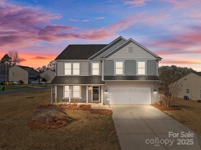 traditional-style house with a yard, cooling unit, a garage, and concrete driveway