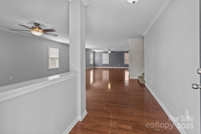 hall featuring stairway, baseboards, wood finished floors, and ornamental molding