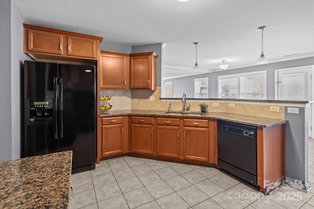 kitchen featuring a sink, brown cabinets, black appliances, and a peninsula