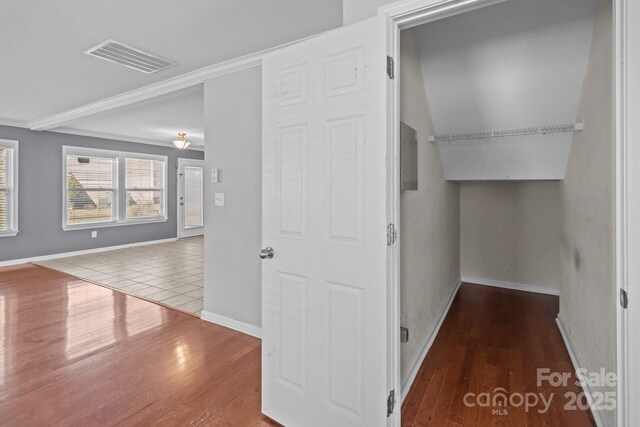 interior space featuring crown molding, wood finished floors, visible vents, and baseboards