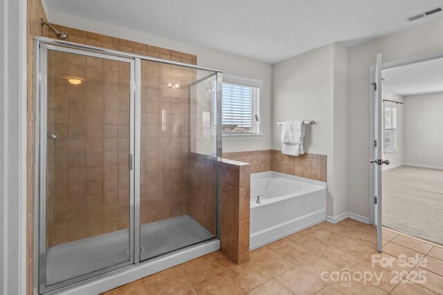 full bathroom with tile patterned floors, a healthy amount of sunlight, visible vents, and a stall shower