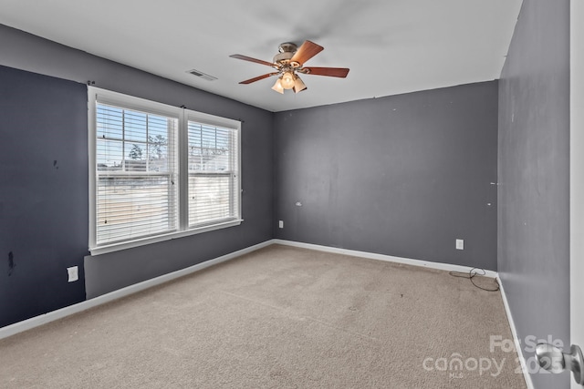 carpeted spare room with a ceiling fan, baseboards, and visible vents