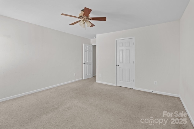 spare room featuring a ceiling fan, carpet, and baseboards