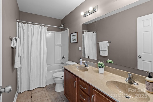 bathroom with tile patterned floors, double vanity, toilet, and a sink