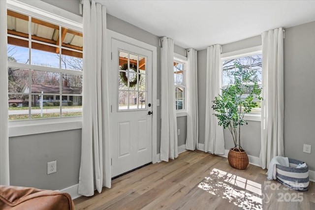 foyer with baseboards and light wood-style flooring