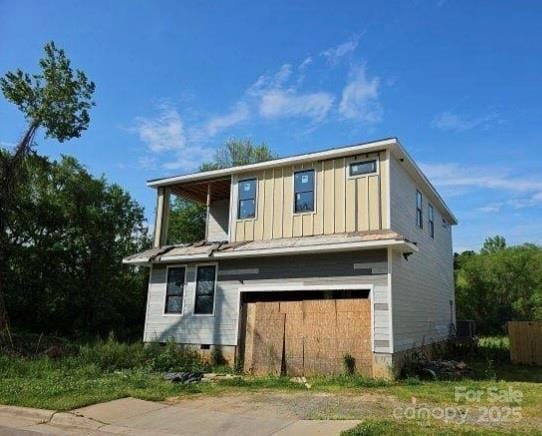 rear view of property with crawl space, board and batten siding, and an attached garage