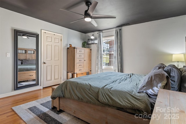 bedroom featuring baseboards, ceiling fan, and wood finished floors