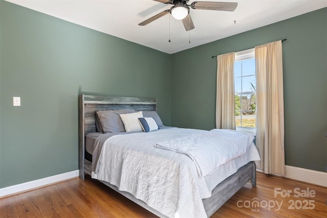 bedroom featuring a ceiling fan, wood finished floors, and baseboards