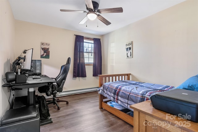 bedroom with a baseboard heating unit, wood finished floors, and ceiling fan