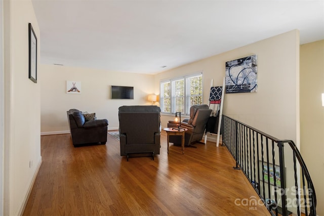 living area with baseboards and wood finished floors
