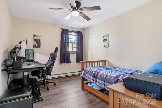 bedroom with ceiling fan, baseboard heating, and wood finished floors