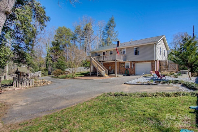 view of front of home with stairway, fence, a garage, aphalt driveway, and brick siding