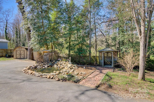 view of front of house with fence, an outdoor structure, and a shed
