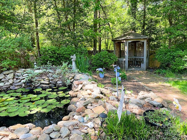 view of yard featuring a small pond and fence