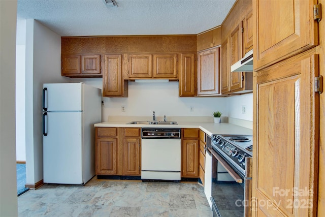 kitchen featuring a sink, brown cabinetry, white appliances, under cabinet range hood, and light countertops