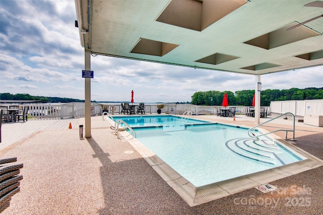community pool with fence, a patio area, and a deck
