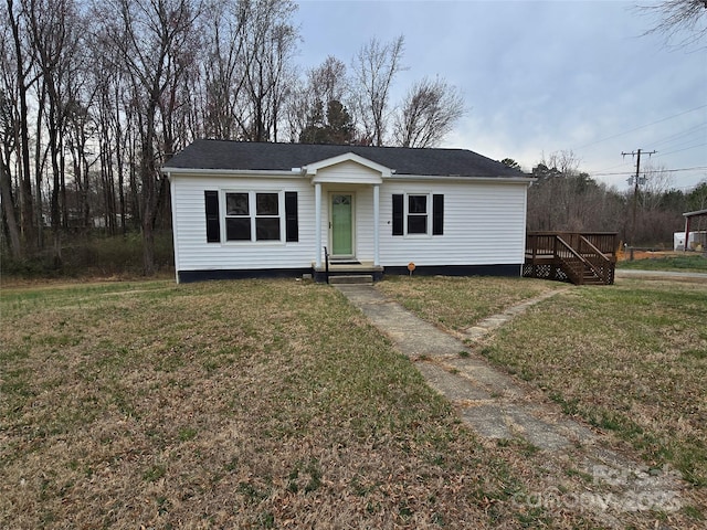 view of front facade featuring a wooden deck and a front yard