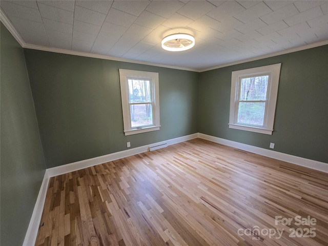 empty room with visible vents, a healthy amount of sunlight, and wood finished floors