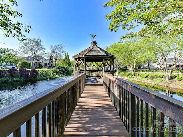 view of dock with a gazebo and a water view