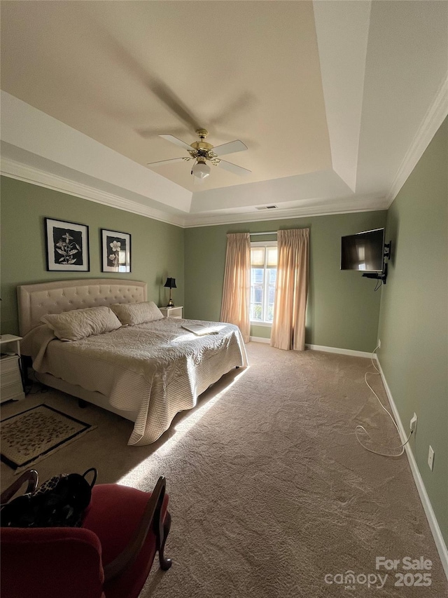 bedroom featuring a ceiling fan, baseboards, ornamental molding, a raised ceiling, and carpet flooring