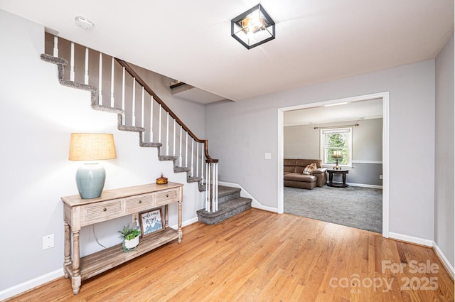 stairs with wood finished floors and baseboards