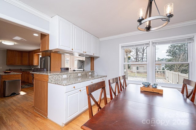 kitchen featuring crown molding, light wood-style floors, and freestanding refrigerator